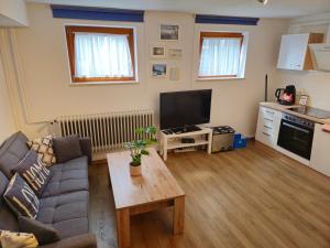 a living room with a couch and a tv at Ruhige, modern eingerichtete 2 Zimmer Wohnung im Untergeschoss eines Zweifamilienhauses in Hildrizhausen