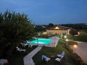 a backyard with a swimming pool and chairs and a house at La Porta del Lugana - Albergo Quattro Pini in Pozzolengo