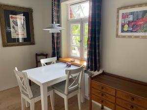 a white table and chairs in a room with a window at Prinzenvilla in Berge