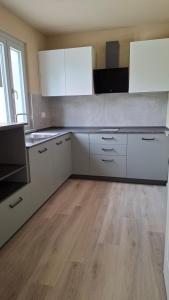 a kitchen with white cabinets and a wooden floor at San Lorenzo Suite in Tigliole