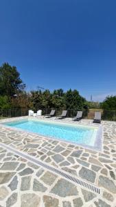 a swimming pool with lounge chairs next to at San Lorenzo Suite in Tigliole