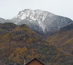 a snow covered mountain with a house in the foreground at Studio dans mon chalet La Mère Veille in La Girard +7 photos