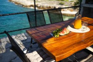 a wooden table with a plate of food and orange juice at Stone house Mia in Čara