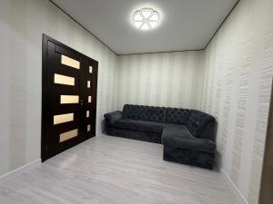 a living room with a couch and a door at Apartament in Chişinău