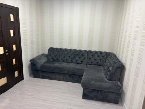 a leather couch sitting in a corner of a room at Apartament in Chişinău