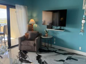 a living room with a chair and a flat screen tv at Spacious 2BR Retreat • Balcony Views + Parking in Nazareth