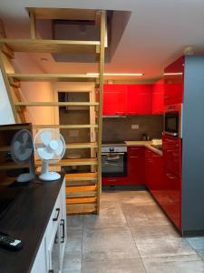 a kitchen with red cabinets and a spiral staircase at Apartmán 2 in Zlín
