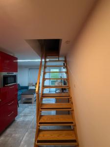 a wooden staircase in a room with a kitchen at Apartmán 2 in Zlín