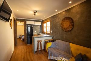 a living room with a couch and a kitchen at Maré Alta - Guest House in Ilha do Mel