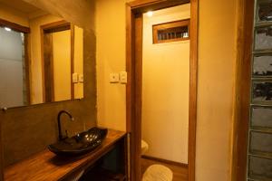 a bathroom with a sink and a mirror at Maré Alta - Guest House in Ilha do Mel