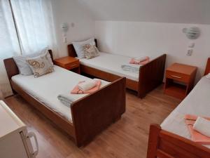 a room with two beds and two tables at Apartmani Sobe Šljivančanin in Žabljak