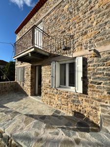 a stone house with a balcony on a building at Hundred Noons in Khandrinós