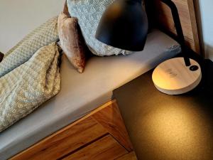 a lamp on a table next to a bed with pillows at Weitblick am Rammenfeld in Schönecken