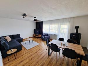 a living room with a blue couch and a table at Weitblick am Rammenfeld in Schönecken