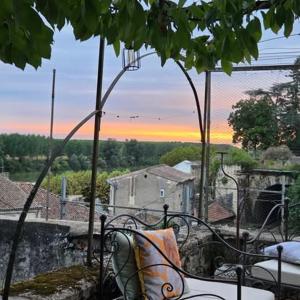 a bench on a balcony with a view of a city at La Villa Regula in La Réole