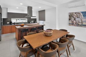 a kitchen with a wooden table and chairs at Sun & Moon Luxury - Eclipse Villa in Ayia Napa