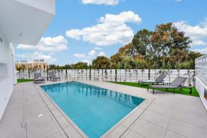 a swimming pool on a patio with two chairs at Sun & Moon Luxury - Eclipse Villa in Ayia Napa