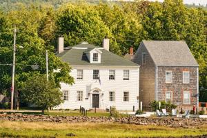 a large white house with a stone wall at Bailey House Inn - Georgian Waterfront Retreat in Annapolis Royal