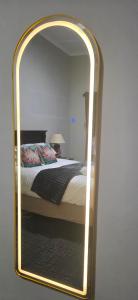 a mirror reflecting a bed in a bedroom at 5Res Stay in Queenstown