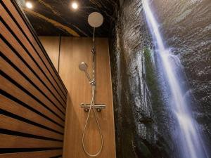 a shower in a room with a painting of a waterfall at Ferienwohnungen auf Reiterhof in Kevelaer in Kevelaer +73 photos