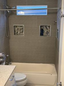 a bathroom with a white tub and a toilet at Spacious cozy in Jacksonville