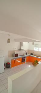a kitchen with orange cabinets and a white counter top at Tropical Orange House in Ducos