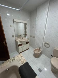 a bathroom with a tub and a toilet and a sink at Apartamento céntrico Prado Blanco in Finisterre +23 photos