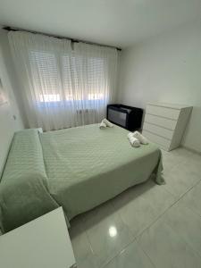 a bedroom with a bed with two towels on it at Apartamento céntrico Prado Blanco in Finisterre