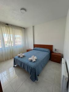 a bedroom with a bed with two towels on it at Apartamento céntrico Prado Blanco in Finisterre