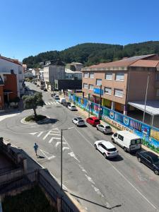 a city street with cars parked on the road at Apartamento céntrico Prado Blanco in Finisterre