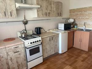 a small kitchen with a stove and a microwave at Marsel Odesa in Odesa +20 photos