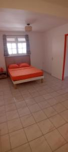 a bedroom with a bed in a room with a window at Tropical Orange House in Ducos