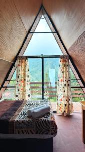 a room with a bed and a large window at Cabañas Ticomulco in Zacatlán
