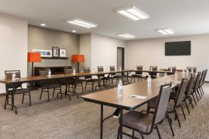 una sala de conferencias con mesas, sillas y una pantalla en Country Inn & Suites by Radisson, Smithfield-Selma, NC en Smithfield