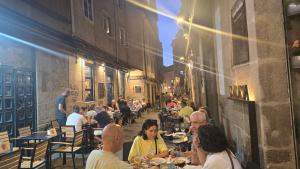 a group of people sitting at tables in a restaurant at Loft Casco Viejo 3 in Ourense