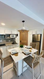 a white kitchen with a white table and chairs at Xanadu Casa De La Playa in Puerto Plata