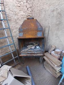 an old stove in a room with a ladder at Casa Rural Forcén in Lumpiaque