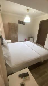 a large white bed in a room with a light at Toprak otel pansiyon in Akhisar