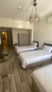 a hotel room with three beds and a chandelier at Toprak otel pansiyon in Akhisar