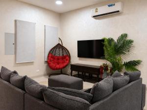a living room with a couch and a tv at Valley Farmhouse By Bait Zain in As Sīfah