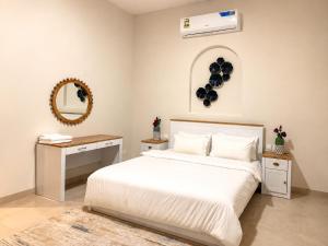 a bedroom with a white bed and a mirror at Valley Farmhouse By Bait Zain in As Sīfah +16 photos