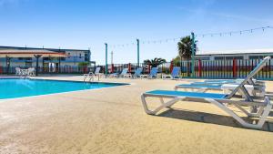 a swimming pool with lounge chairs next to a building at CRYSTAL PALACE RESORT in Bolivar Peninsula
