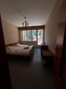 a bedroom with two beds and a large window at Hôtel Grand-Combin in Fionnay +2 photos