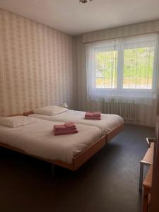a bedroom with a bed with two towels on it at Hôtel Grand-Combin in Fionnay