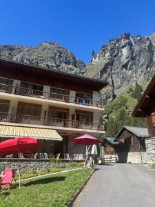a building with tables and umbrellas in front of it at Hôtel Grand-Combin in Fionnay