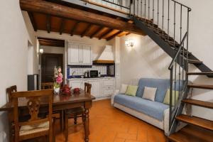 a living room with a table and a staircase at Accademia Residence in Prato