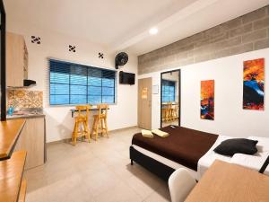 a bedroom with a large bed and a kitchen at La Gruta Coliving in Medellín