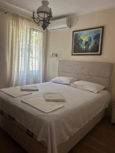 a bedroom with a large white bed with a window at Guest House Budva in Budva
