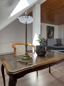 a table with a lamp and a vase on it at Kalna Raskumu Apartamenti in Vecpiebalga