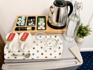 a table with a tray with a tea set and a kettle at High Trees Guest House Gatwick in Horley